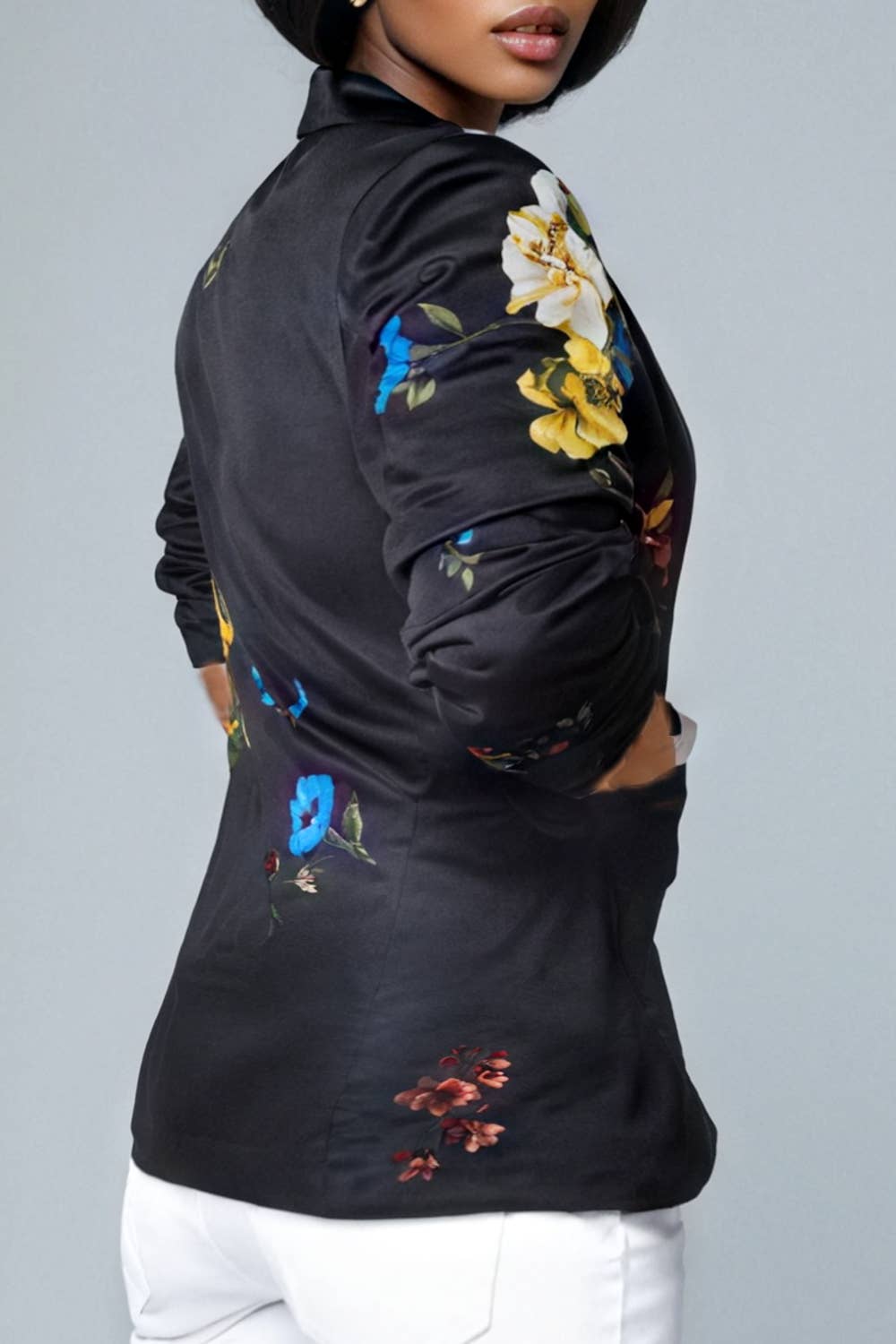 Black bomber jacket with colorful floral embroidery on a gray background