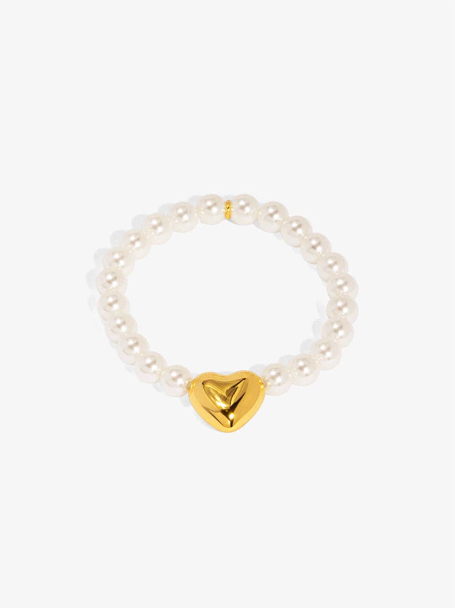 Pearl bracelet with a gold heart charm on a white background