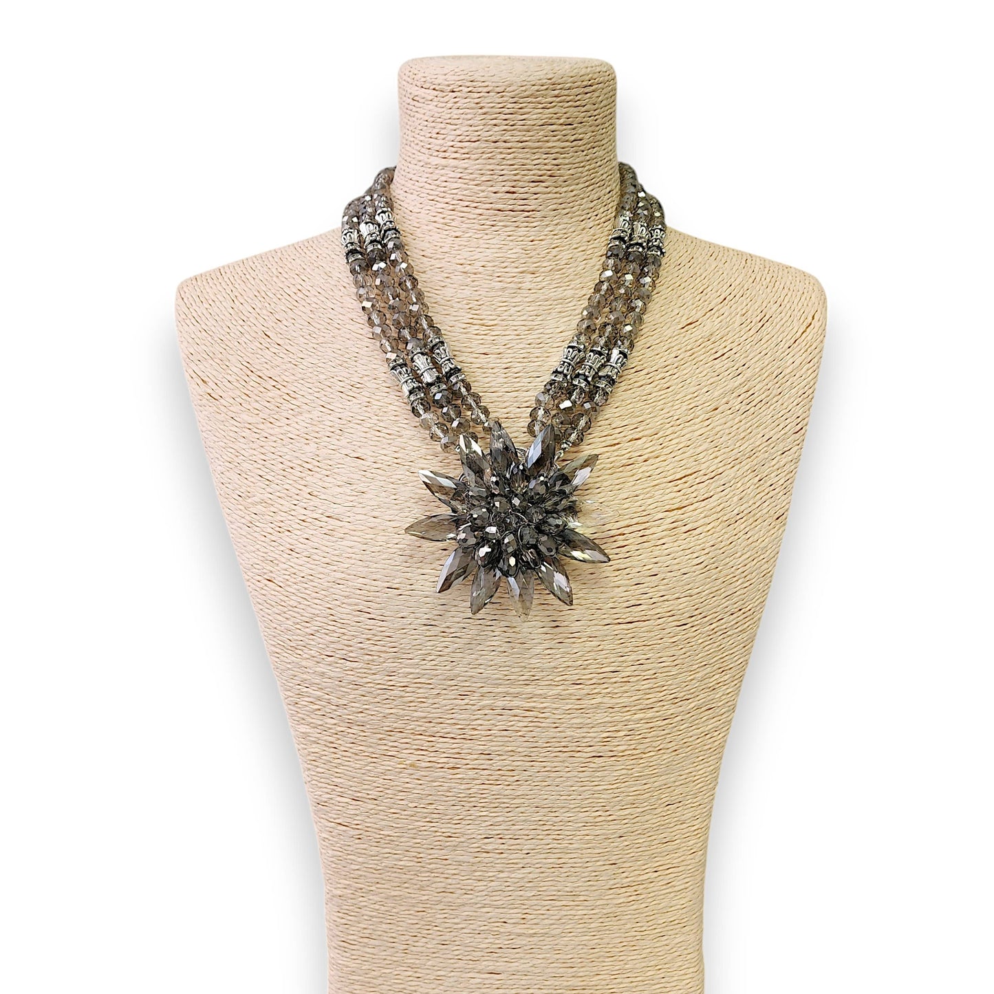 Necklace with a large decorative clasp on a mannequin bust against a white background