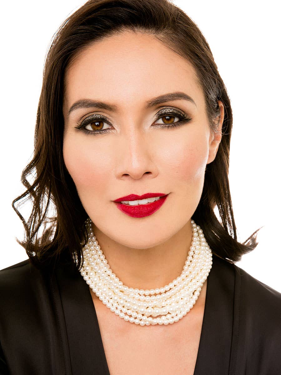 Woman wearing a pearl necklace against a white background