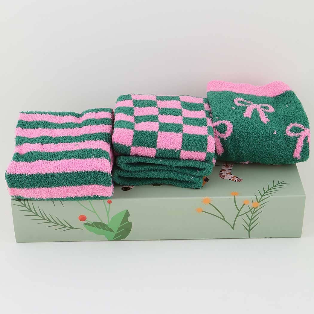 Set of green and pink checkered towels with a bow design on a decorative box.