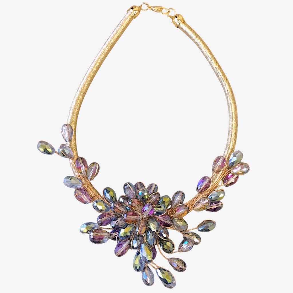 Multicolored crystal necklace on a gold chain against a white background