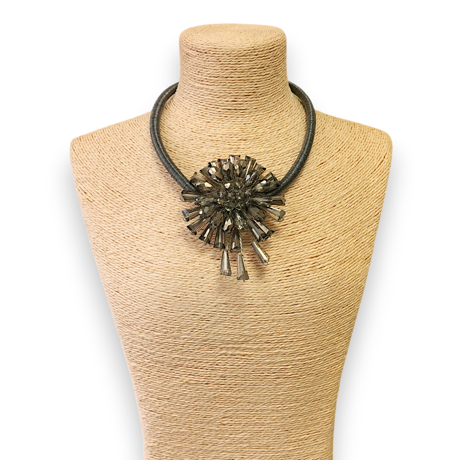Necklace with a large, intricate pendant on a beige mannequin bust against a white background