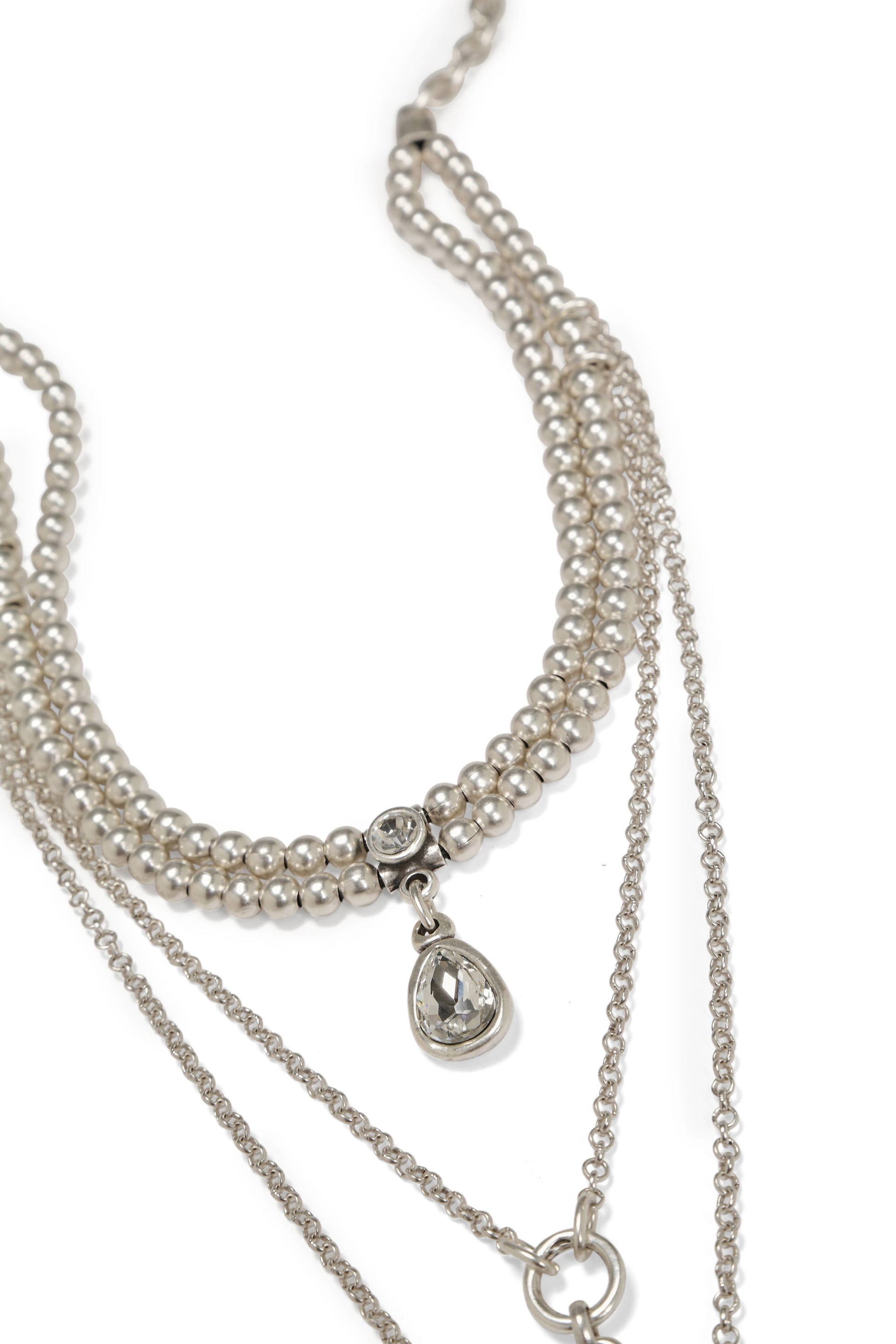 Silver necklace with multiple strands and a teardrop pendant on a white background