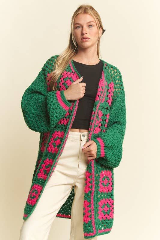 Woman wearing a green and pink patterned cardigan on a beige background