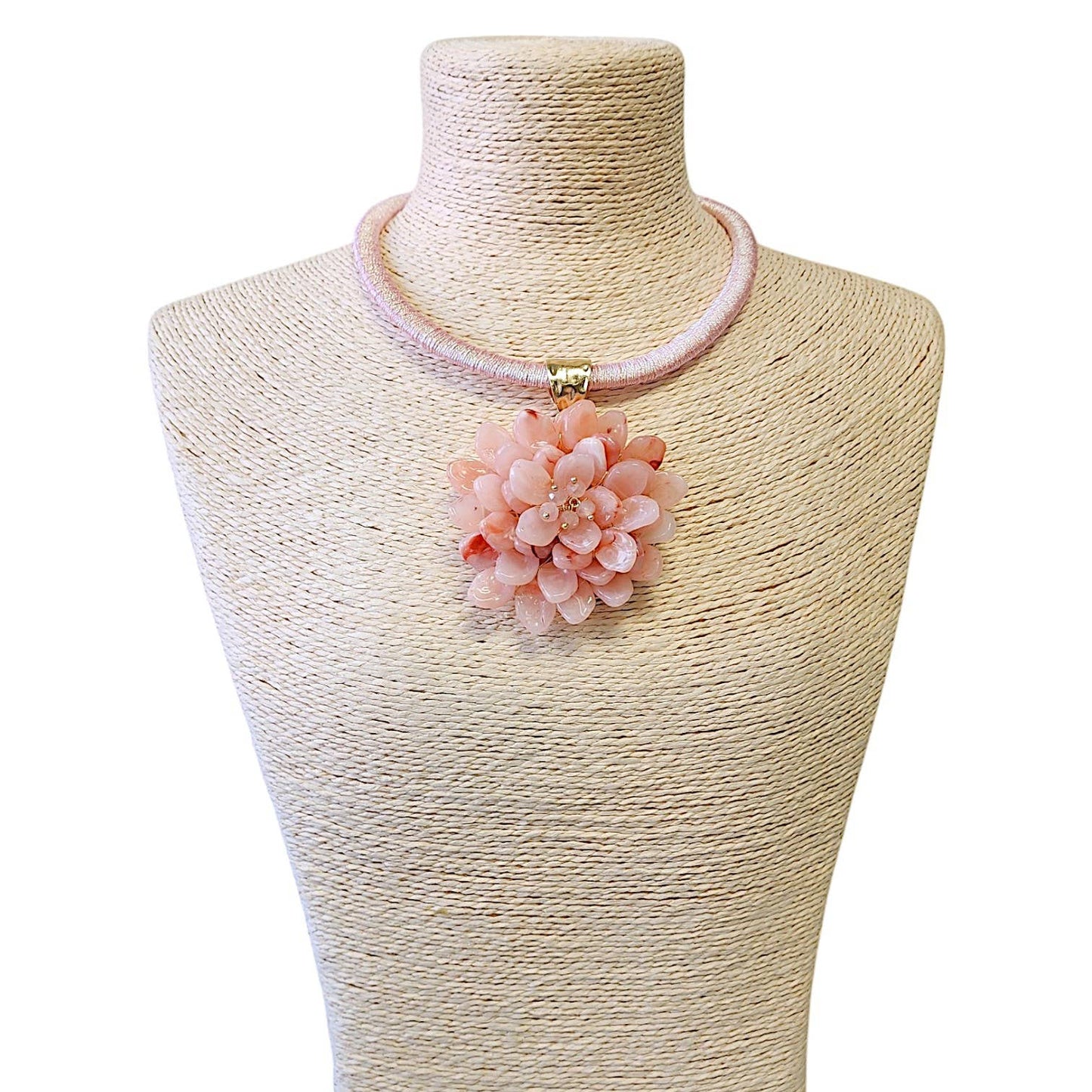 Necklace with a pink floral pendant on a mannequin bust.