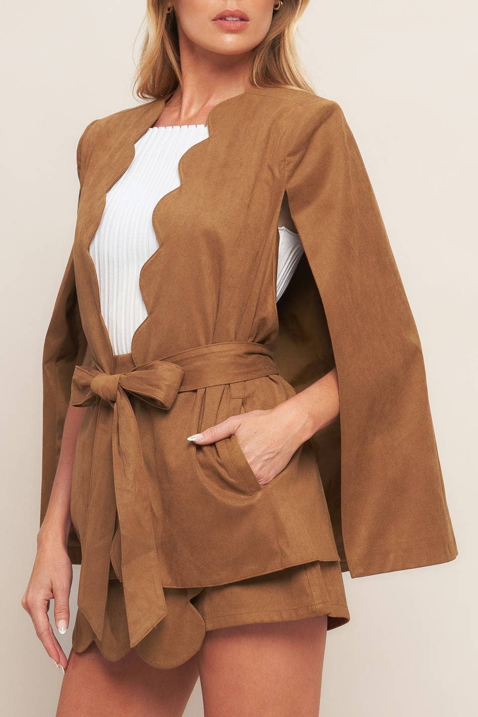 Brown outfit with a belt and shorts on a neutral background