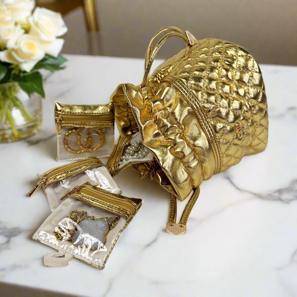 Gold decorative armadillo with small framed artworks on a marble surface