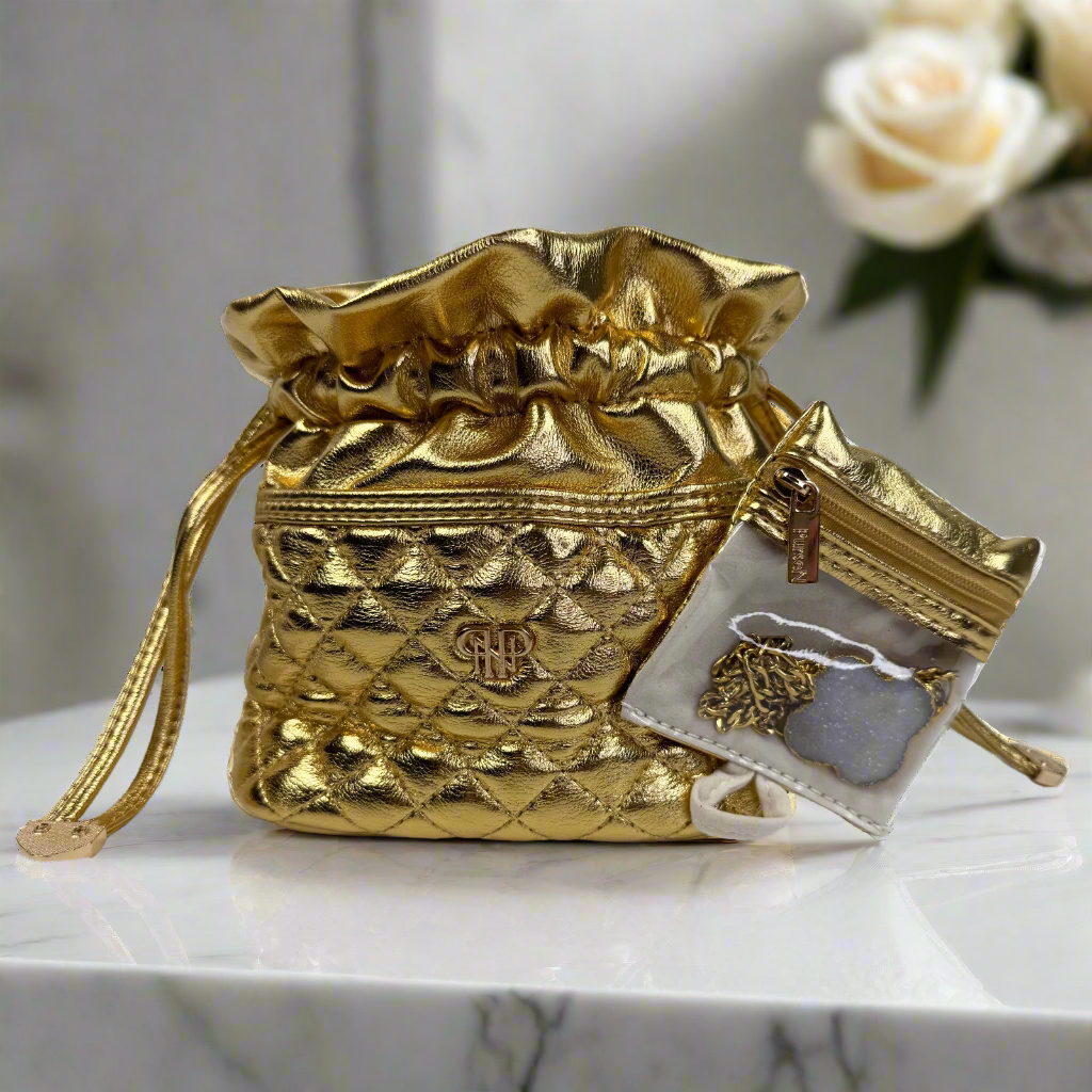 Gold drawstring bag with a small pouch on a marble surface