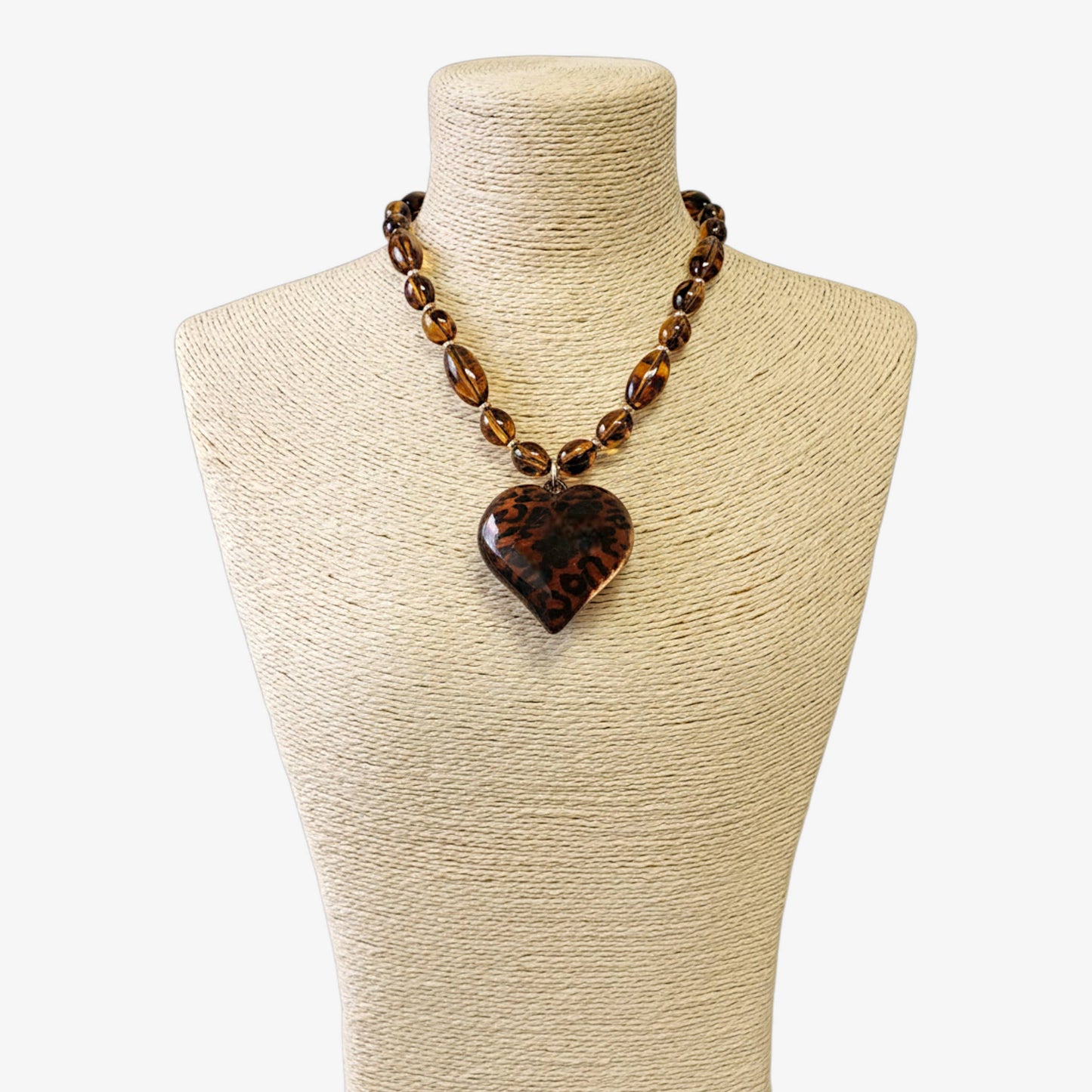 Necklace with a heart-shaped pendant on a mannequin bust against a white background