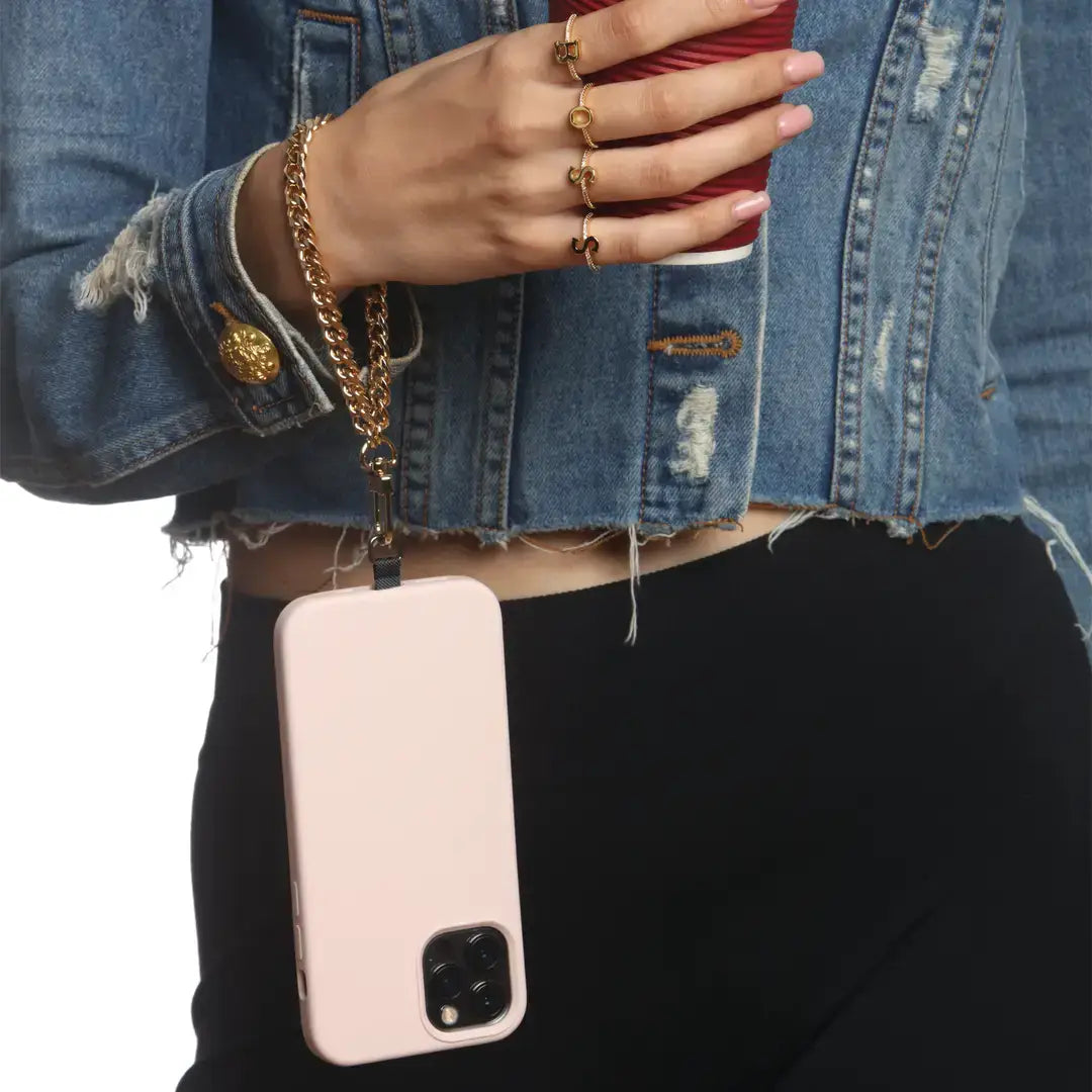 Person holding a red phone with a pink phone case on a plain background