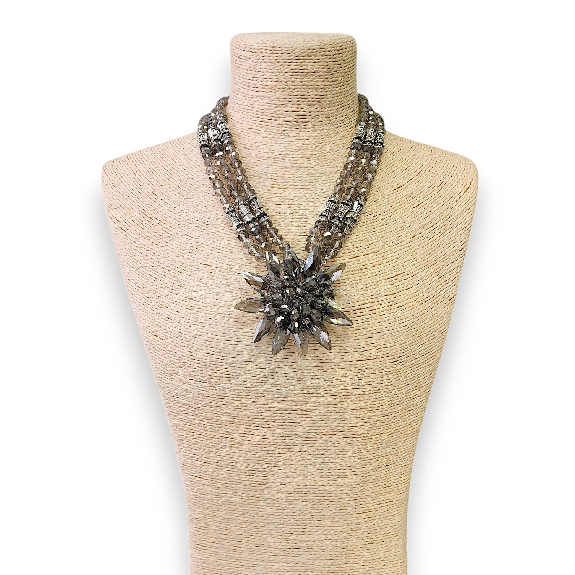 Necklace with a large decorative clasp on a mannequin bust against a white background