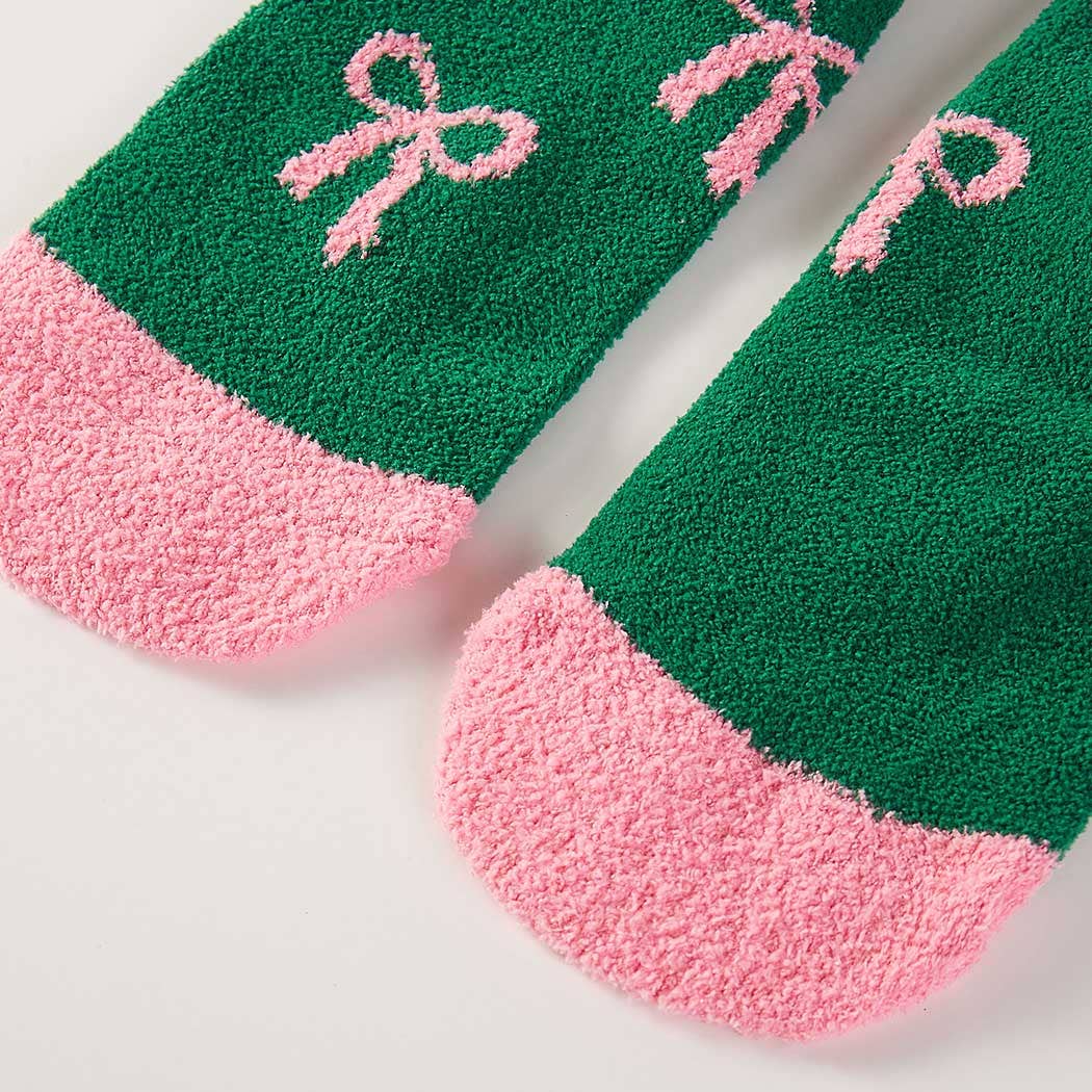 Green socks with pink bows and text on a white background