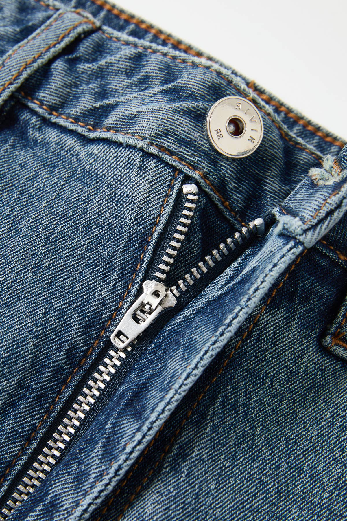Close-up of a blue denim zipper on a white background