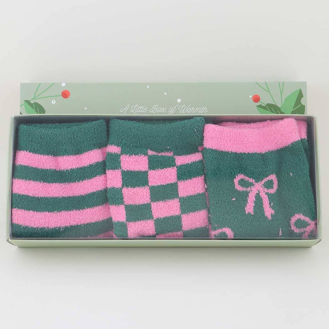 Set of pink and green socks in a decorative box on a white background