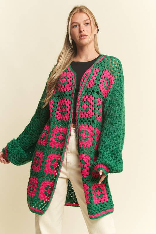 Woman wearing a green and pink patterned cardigan on a beige background