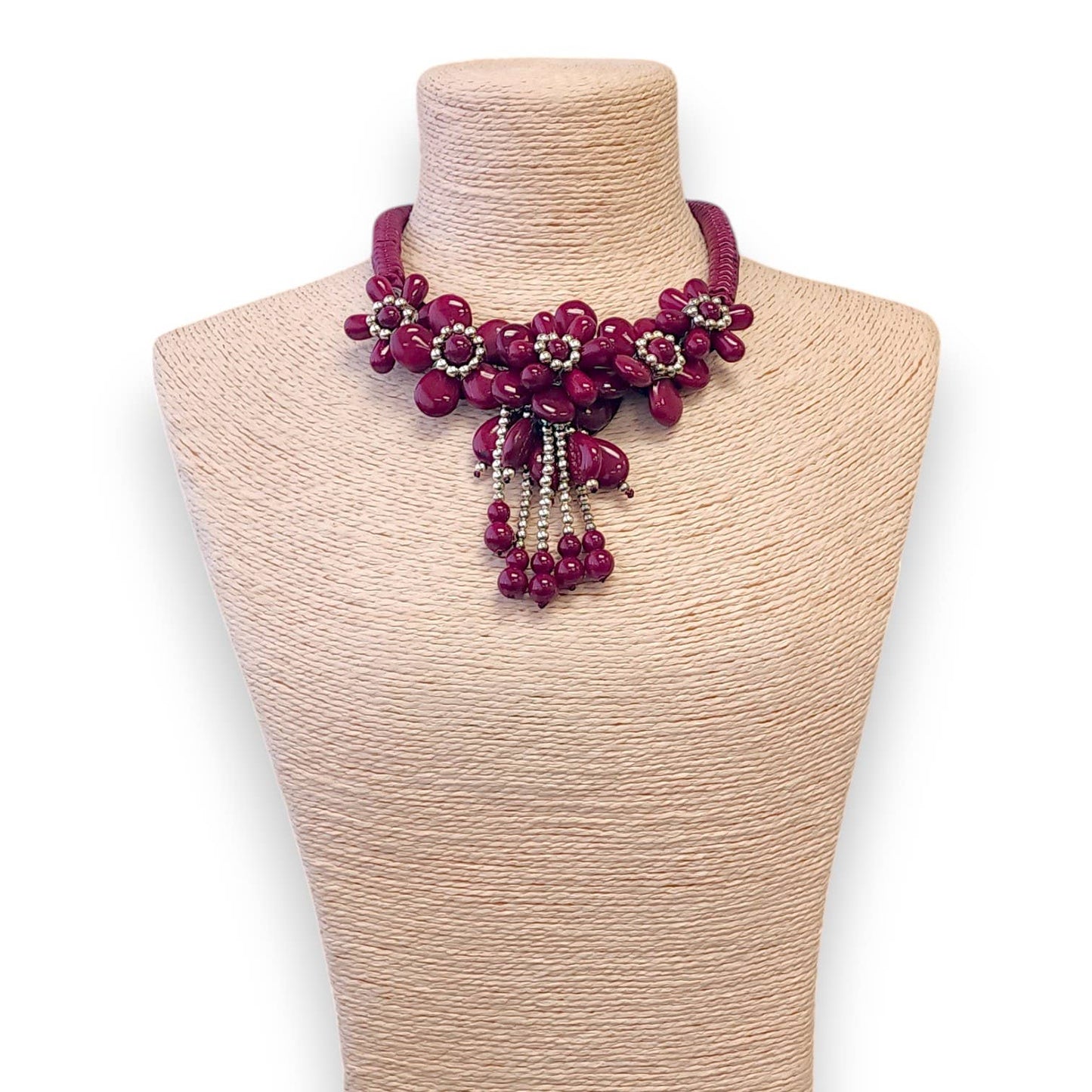 Necklace with pink beads on a mannequin bust against a white background