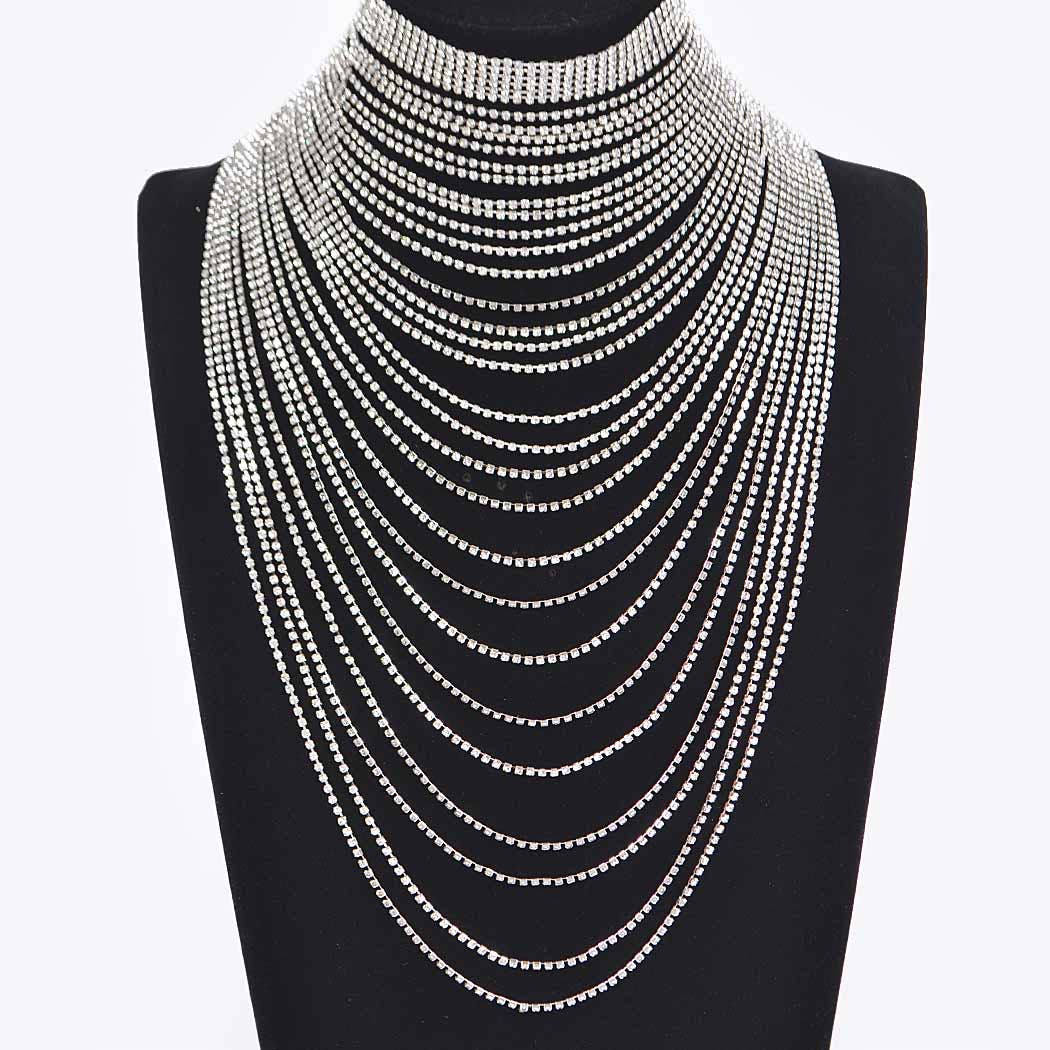 Multiple layered necklaces on a black mannequin bust against a white background