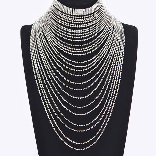 Multiple layered necklaces on a black mannequin bust against a white background
