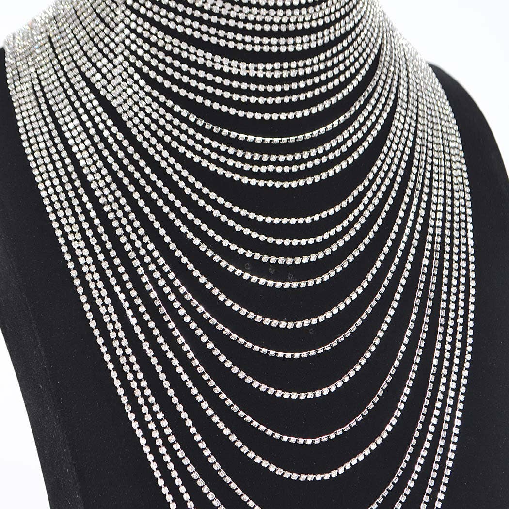 Multiple layers of silver chain necklaces on a black bust