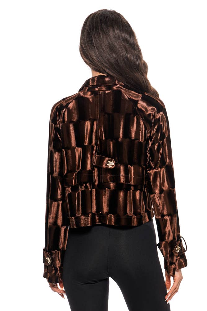 Woman wearing a patterned brown jacket on a white background