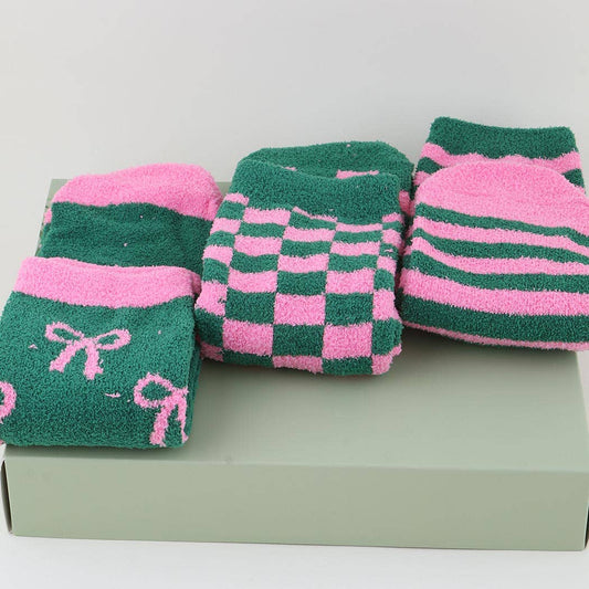 Three pairs of green and pink socks with different patterns on a light gray background.