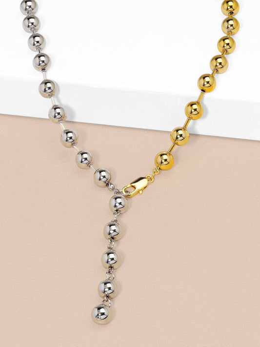 Two necklaces with silver and gold beads on a beige surface