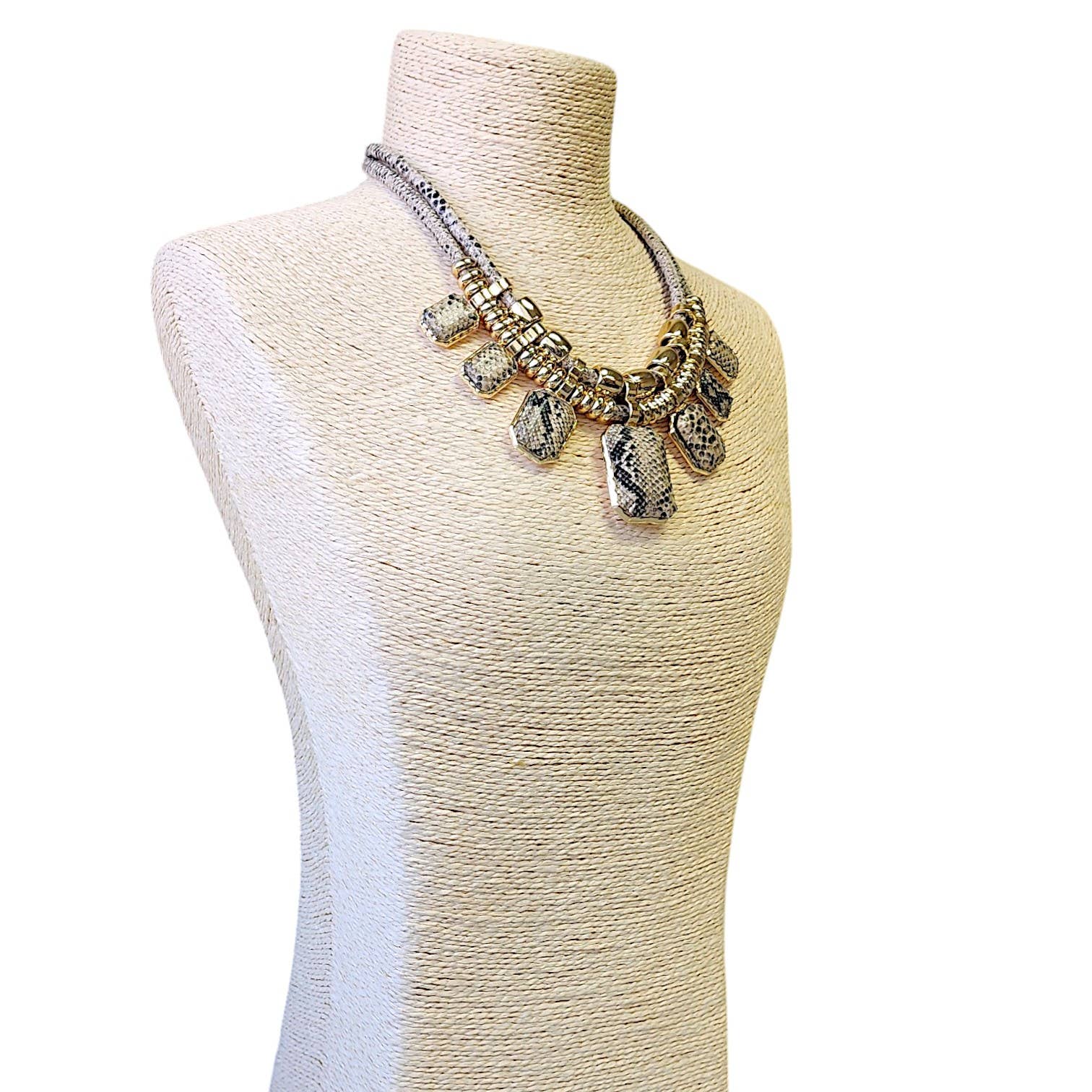 Necklace on a mannequin bust with a plain background
