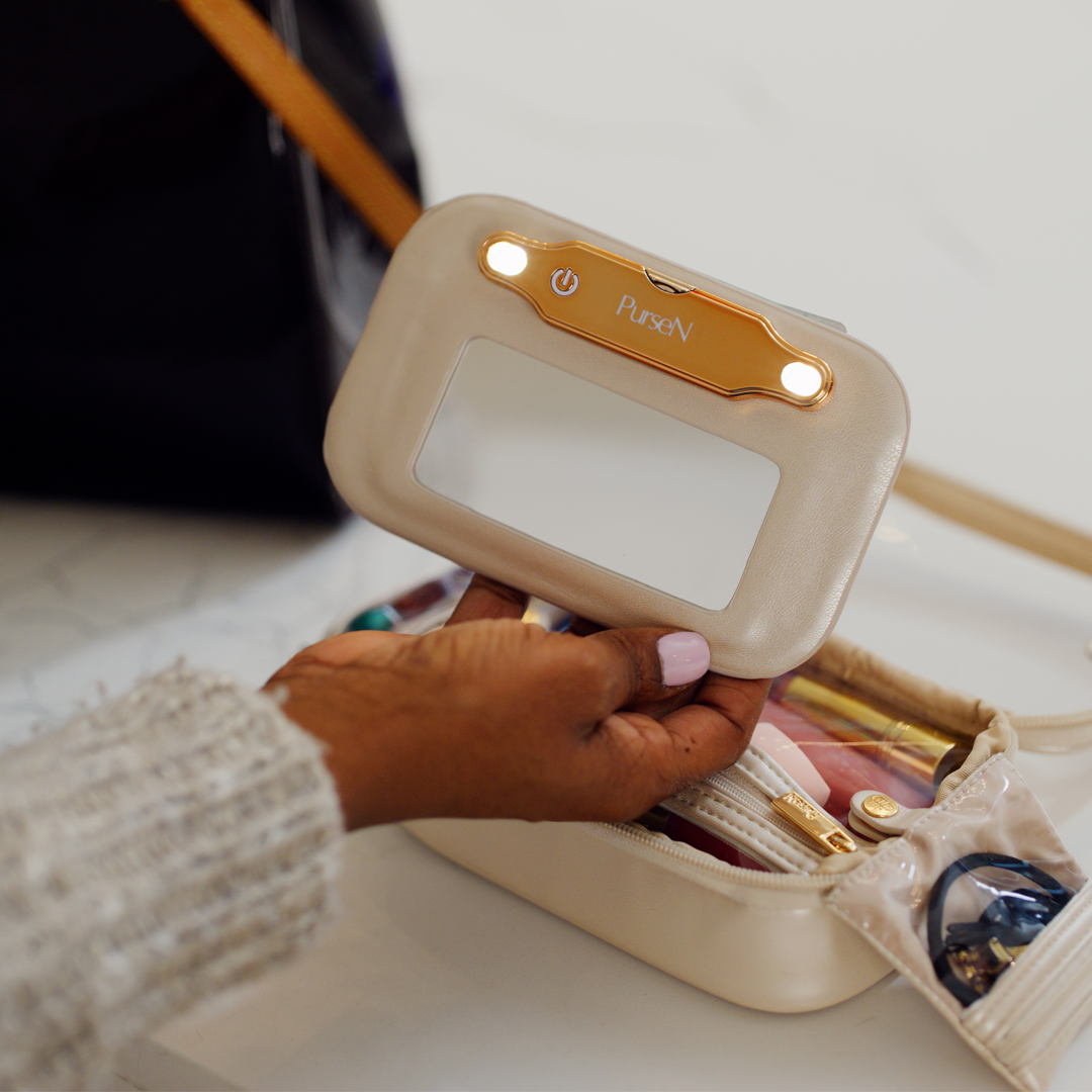 Hand holding a small electronic device labeled 'PurseN' over an open handbag.