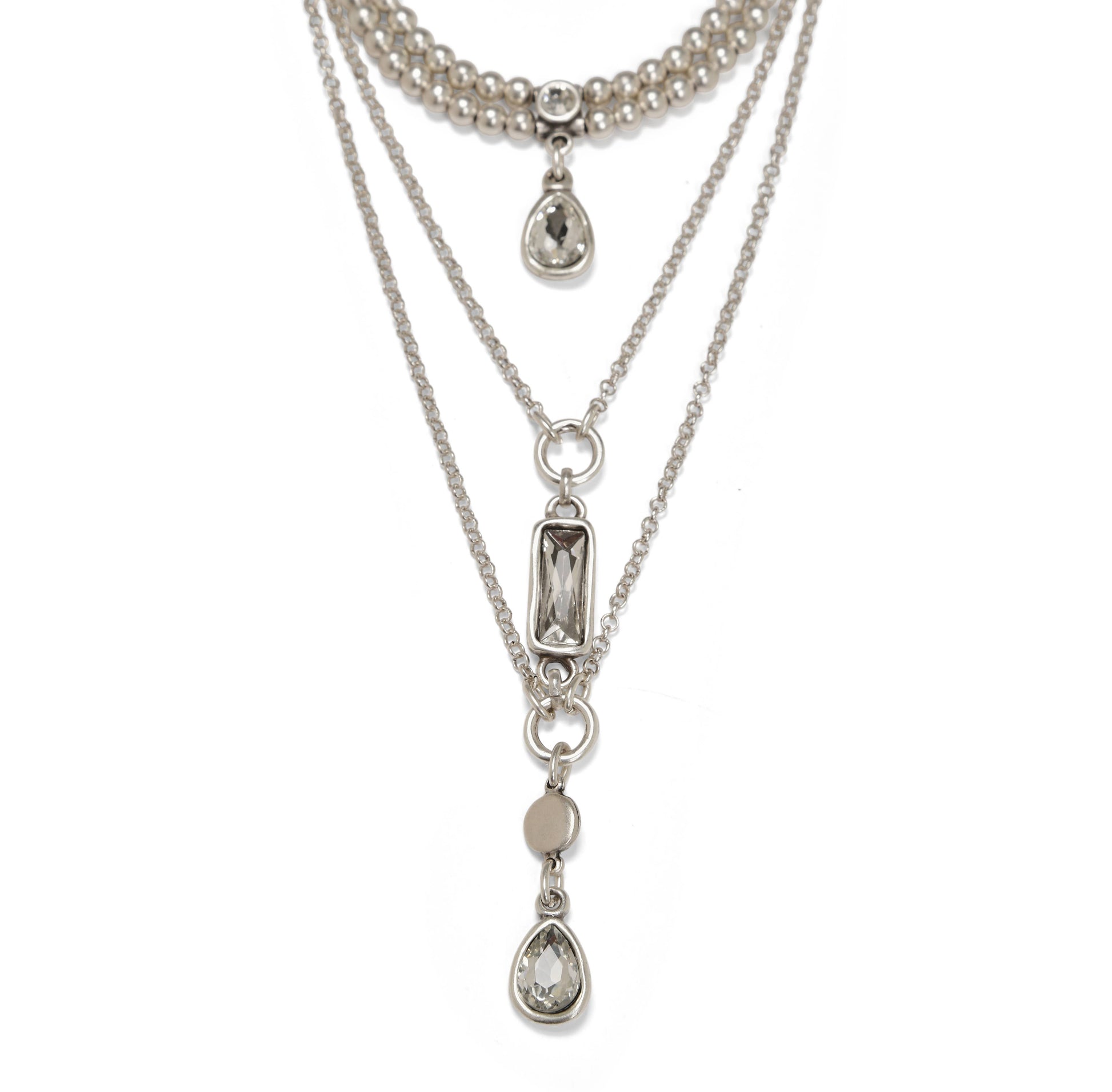 Layered silver necklaces with teardrop pendants on a white background