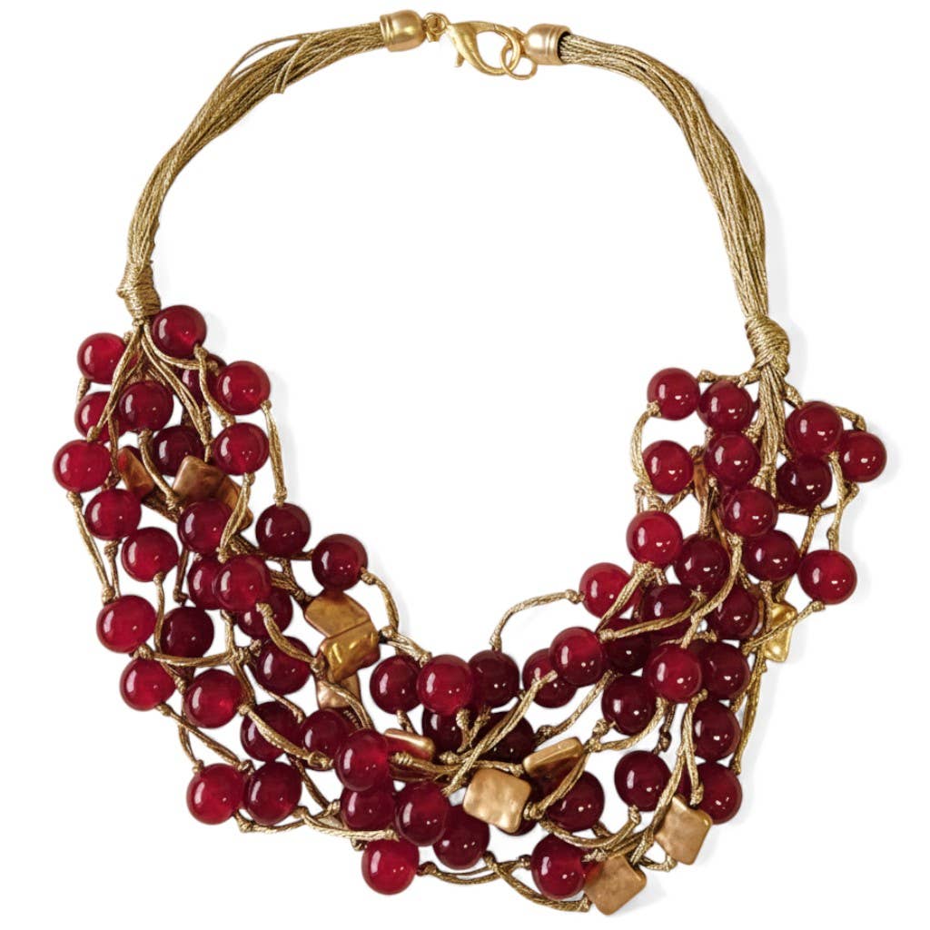 Necklace with red beads and gold accents on a white background