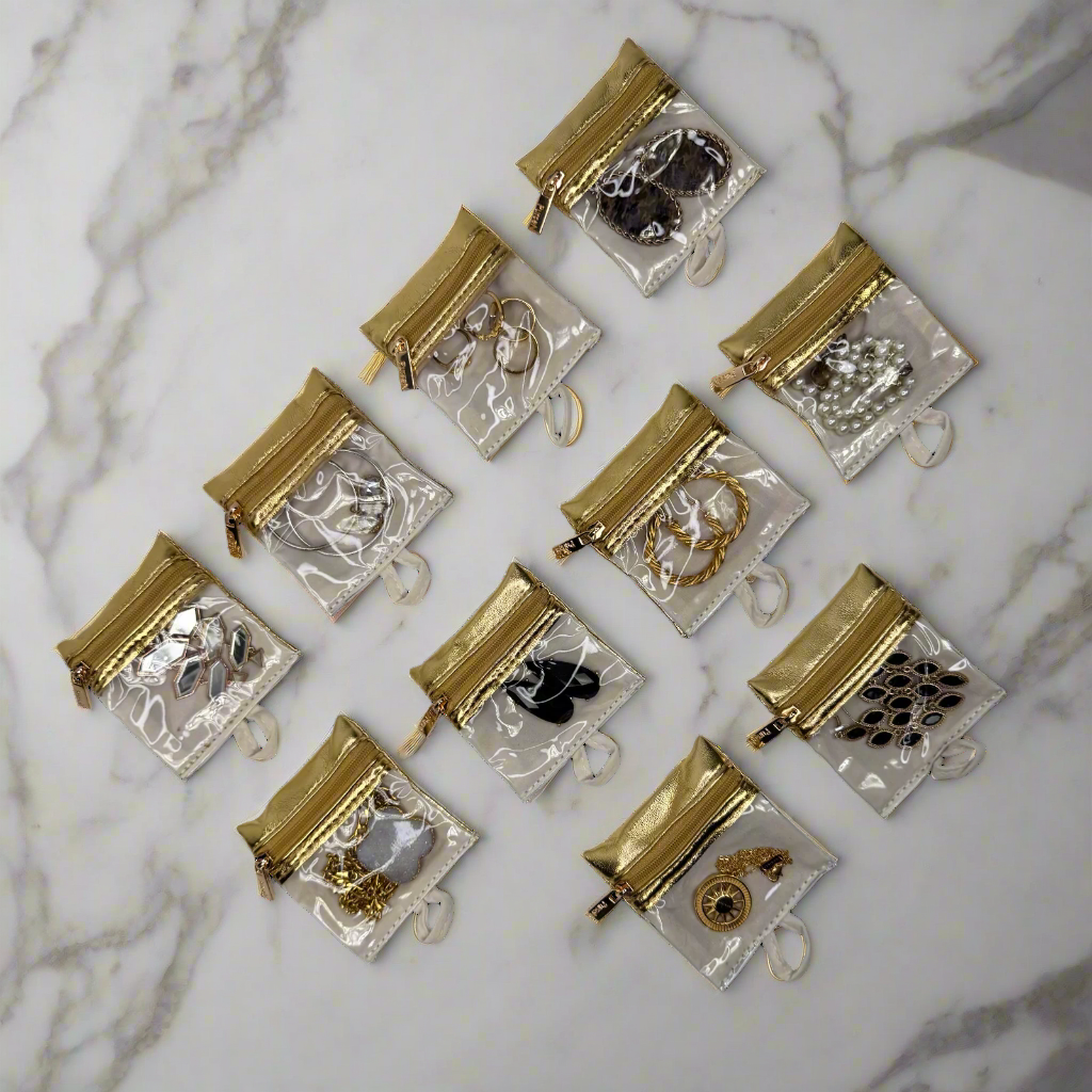 Small gold and silver jewelry pouches on a marble surface